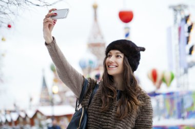 Genç güzel kadın turist üstünde hareket eden telefon fotoğraf çekmek