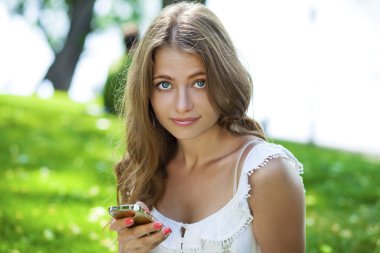 Mutlu güzel sarışın kız bir yaz sokakta telefonla arama