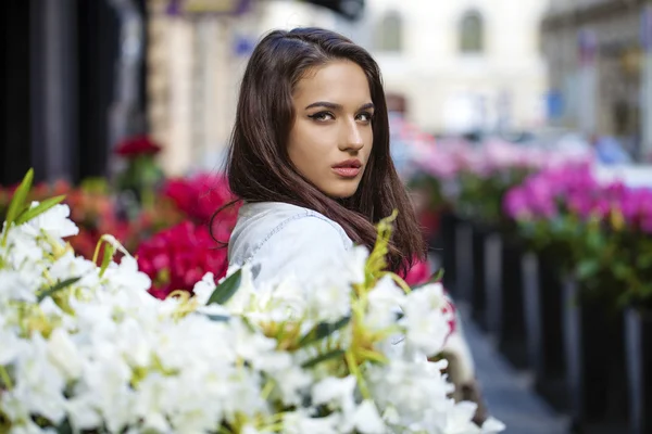 Giovane donna bruna in jeans giacche che camminano per strada — Foto Stock