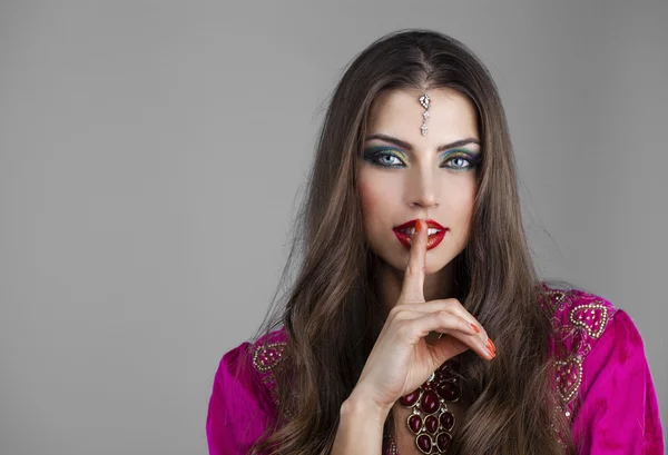 Porträtt av attraktiv ung kvinna med fingret på läppar — Stockfoto