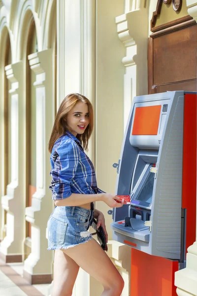Brunette jonge dame met behulp van een automatische telmachines. vrouw intrekking van geld of betaalrekening evenwicht — Stockfoto