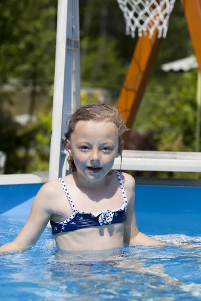 Kind meisje in blauwe bikini in de buurt van zwembad. warme zomer — Stockfoto