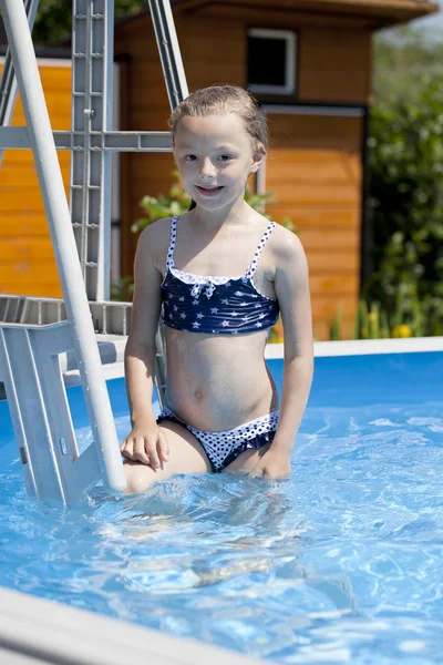 Kind meisje in blauwe bikini in de buurt van zwembad. warme zomer — Stockfoto