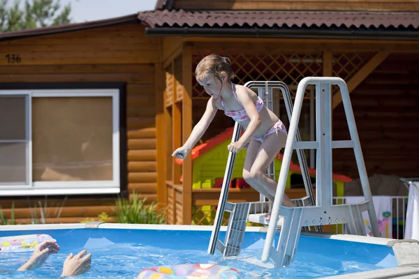 Ребенок в бикини купается в бассейне с отцом — стоковое фото