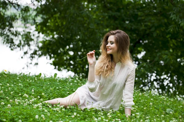 緑の牧草地に若いブロンドの女性 — ストック写真