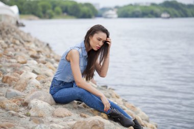 Nehrin buzlu üzerinde oturan genç güzel esmer kız 