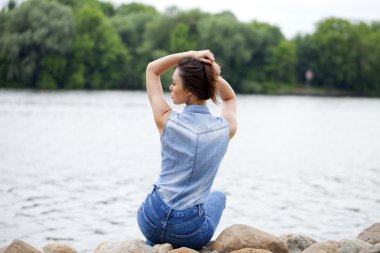 Nehrin buzlu üzerinde oturan genç güzel esmer kız 