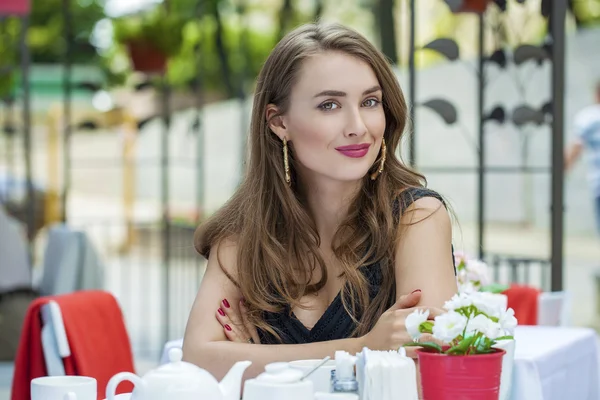 Hübsche junge blonde Frau sitzt im Café — Stockfoto