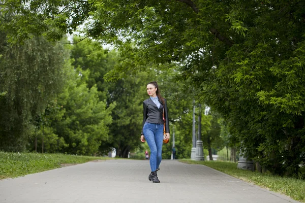 Young beautiful girl in blue jeans and a blue shirt on the backg — Stock Photo, Image