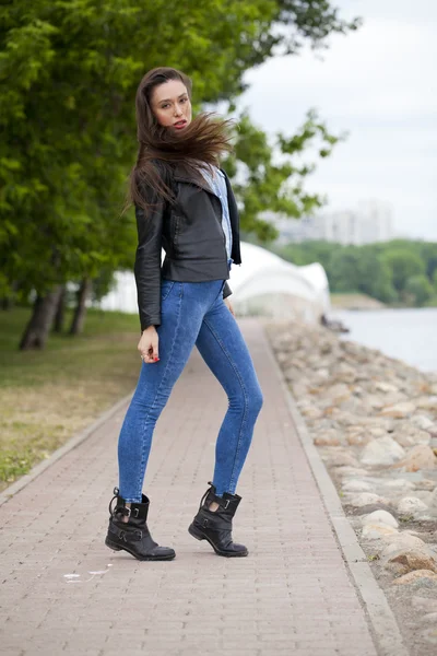 Joven hermosa chica en pantalones vaqueros azules y una camisa azul en la espalda —  Fotos de Stock