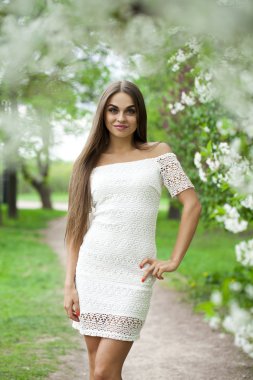 Arka plan bahar f karşı beyaz elbiseli mutlu genç kadın