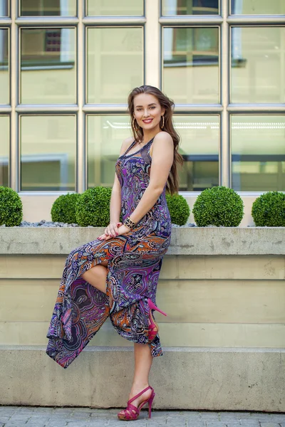 Beautiful young woman in long colorful dress — Stock Photo, Image