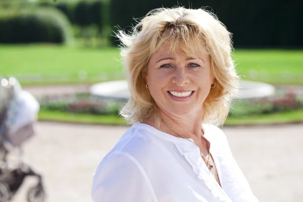 Portrait of serene mature woman in the summer park — Stock Photo, Image