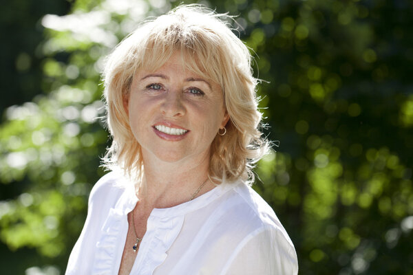 Портрет прекрасной женщины средних лет в летнем парке
 