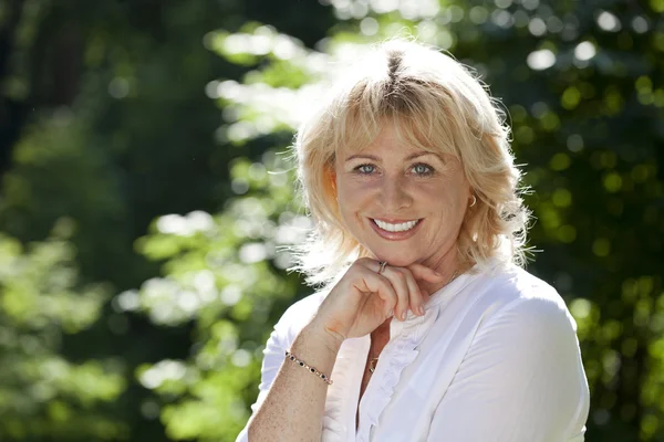 Retrato de una encantadora mujer de mediana edad en el parque de verano — Foto de Stock