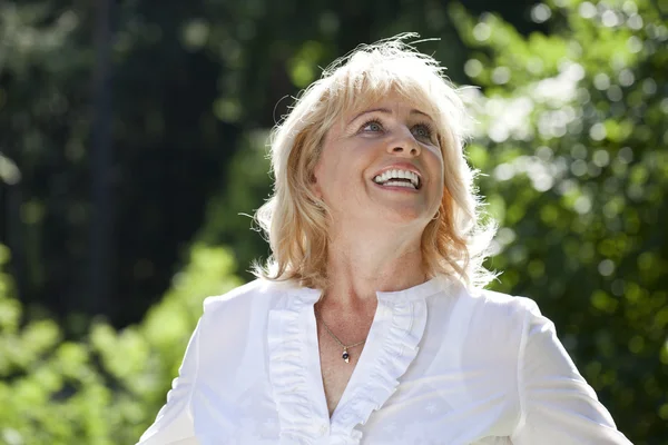 Retrato de una encantadora mujer de mediana edad en el parque de verano — Foto de Stock