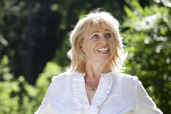 Portrait of serene mature woman in the summer park — Stock Photo, Image