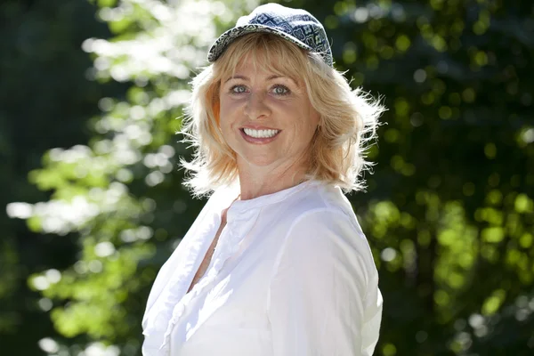 Portrait of serene mature woman in the summer park — Stock Photo, Image