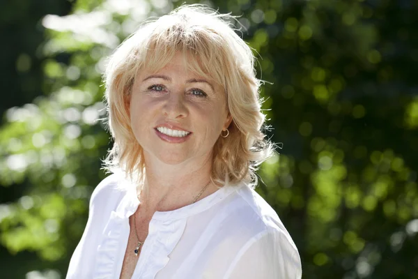 Portret van mooie midden leeftijd vrouw in de zomer park Rechtenvrije Stockfoto's