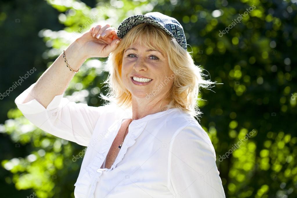 Portrait of lovely middle aged woman in the summer park 