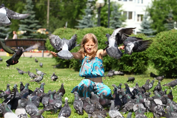 街で鳩の餌の幸せな女の子 — ストック写真