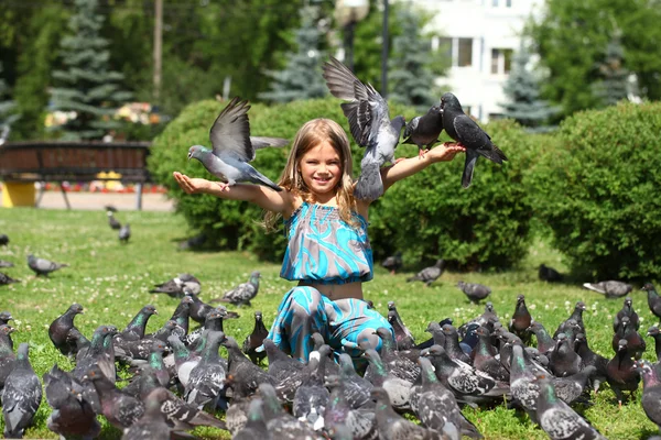 Szczęśliwa dziewczynka karmienia gołębi w mieście ulicy — Zdjęcie stockowe