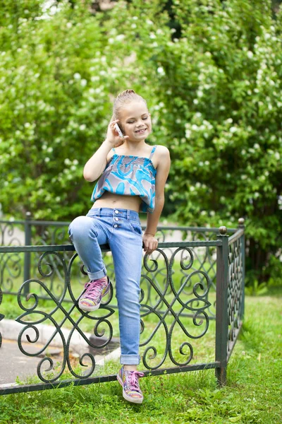 Niña hablando por teléfono celular contra Green of Park en Summe — Foto de Stock