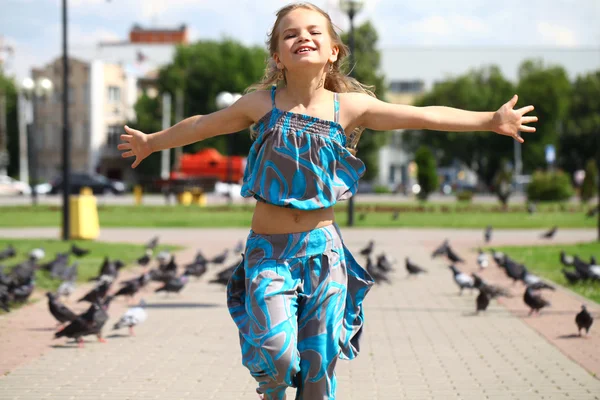広場に鳩の群れを通る若い幸せな女の子 — ストック写真
