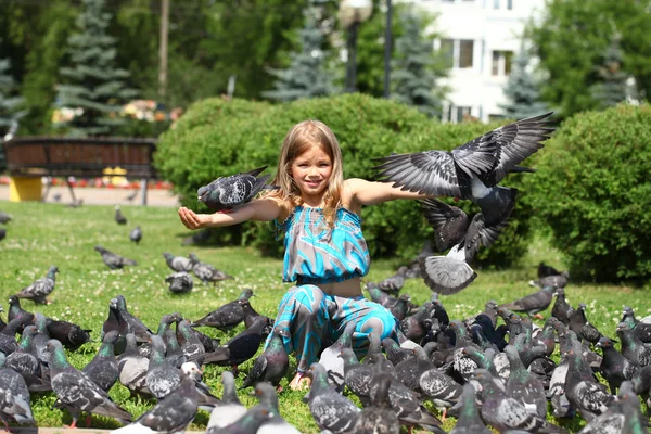 街で鳩の餌の幸せな女の子 — ストック写真