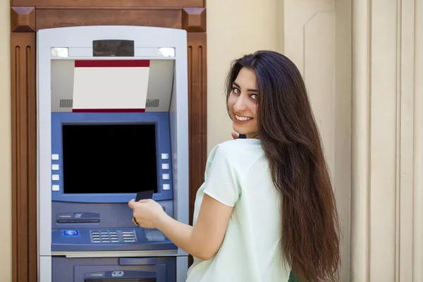 Giovane donna in jeans breve utilizzando un sportello automatico — Foto Stock