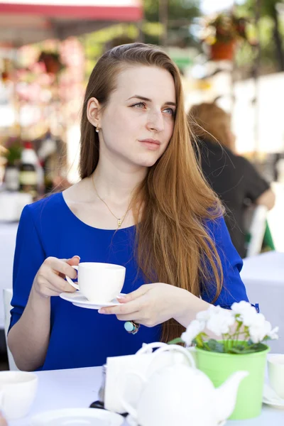 Pretty young blonde woman sitting in the cafe — Stock fotografie