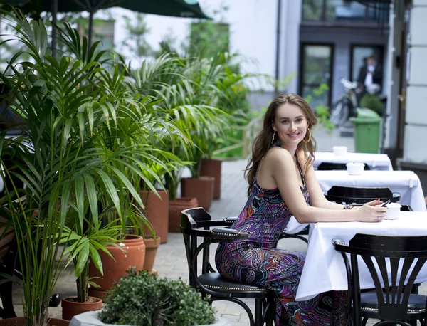 Mulher morena muito jovem sentada no café — Fotografia de Stock