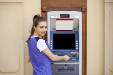 Bir otomatik vezne makinesi kullanarak yaz içinde genç kadın 