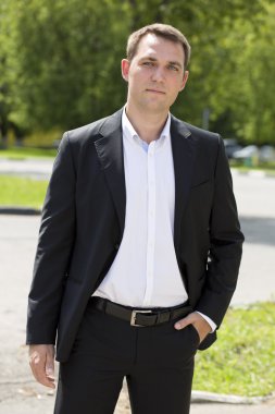 Bir koyu takım elbise ve beyaz gömlek bir genç iş adamı portresi 