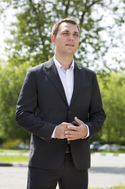 Bir koyu takım elbise ve beyaz gömlek bir genç iş adamı portresi 