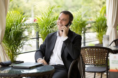 Cep telefonunuzun açık restoranda genç işadamı