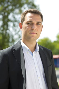 Bir koyu takım elbise ve beyaz gömlek bir genç iş adamı portresi 