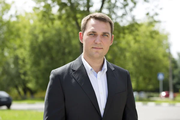 Portrait of a young business man in a dark suit and white shirt — Stock Photo, Image