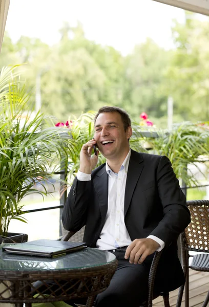 Jovem empresário usando telefone celular no restaurante ao ar livre — Fotografia de Stock