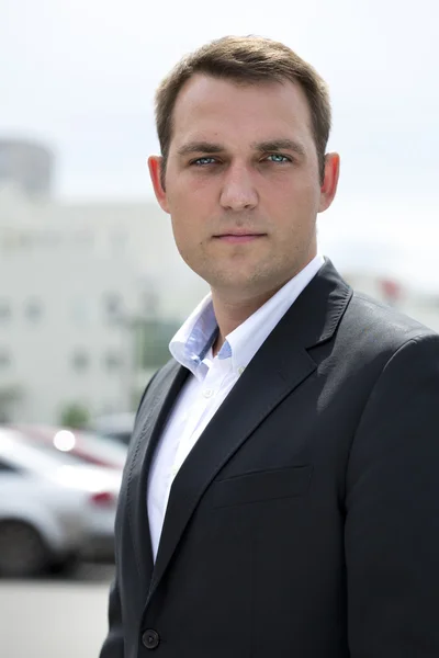 Portrait of a young business man in a dark suit and white shirt — Stock Photo, Image