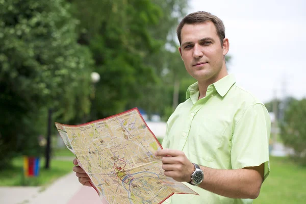 Junge männliche Touristin mit Karte in der Hand gut aussehend. — Stockfoto