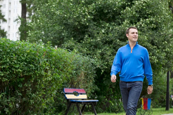 Casual young man walking in the summer park — Stock Photo, Image