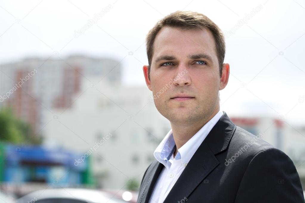 Portrait of a young business man in a dark suit and white shirt 