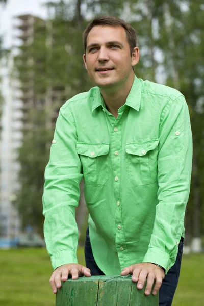 Junger gutaussehender Mann in grünem Hemd auf dem Hintergrund des Sommers — Stockfoto