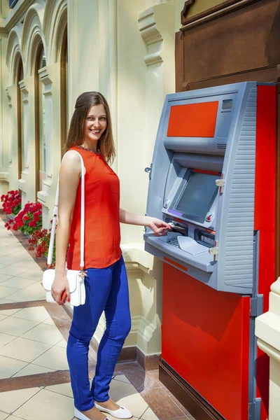 Wanita muda menarik uang dari kartu kredit di ATM — Stok Foto