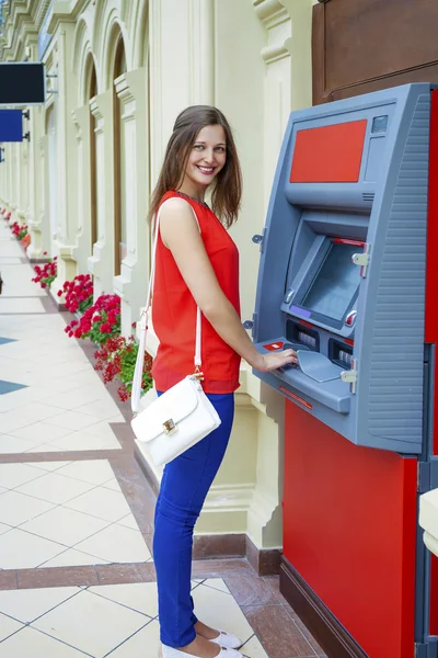 Wanita muda menarik uang dari kartu kredit di ATM — Stok Foto