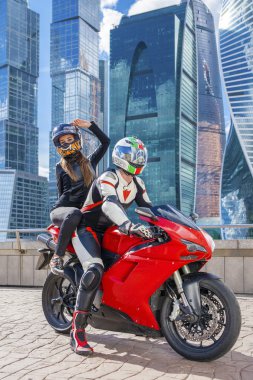 Arka planda bir motosiklet spor bisikleti ile takım elbiseli birkaç kentsel yüksek binalar