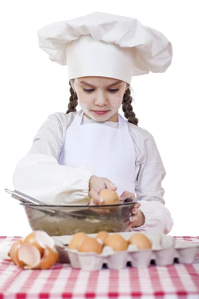 Niña en un delantal blanco y chefs sombrero amasar la masa en th — Foto de Stock