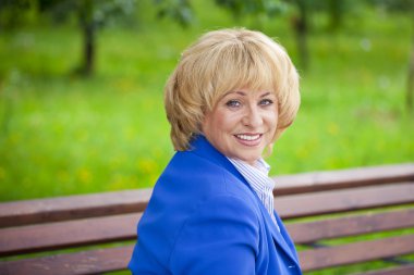 Portrait of an elderly beautiful woman in blue jacket