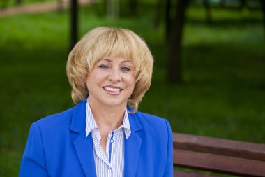 Portrait of an elderly beautiful woman in blue jacket
